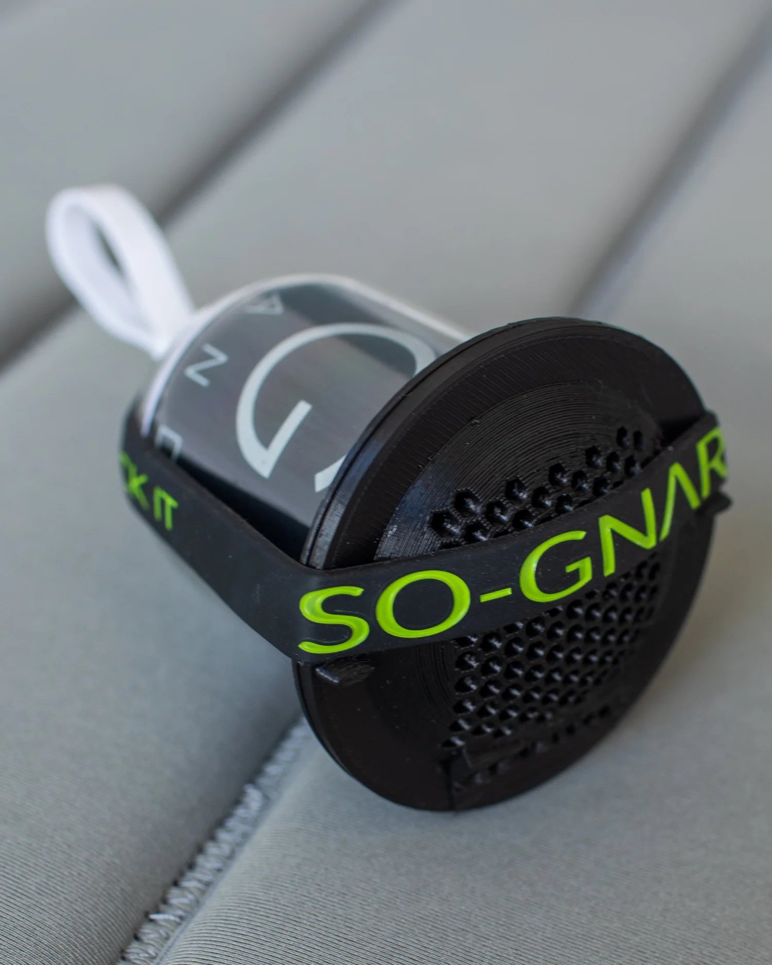 Black SO-GNAR device with green text on a gray surface